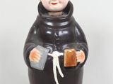 une image représentant une figurine de moine tenant un livre