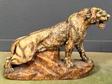 statue of a lion on a rock with its mouth open