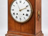 une vieille horloge en bois dont le cadran porte des chiffres romains