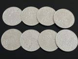 six types différents de pièces d'argent sur une surface noire