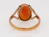 a close up of a ring with an orange stone in it