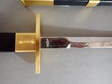 a black and gold sword with a gold handle