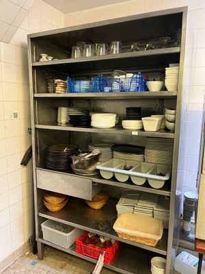 de nombreux plats et bols sur les étagères de la cuisine