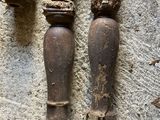 two old wooden candles that are on a stone wall