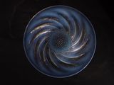 a blue plate with a spiral design on it