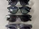four pairs of sunglasses are lined up on a white surface