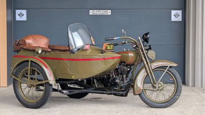 a motorcycle with a side car parked in front of a garage