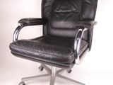 fauteuil de bureau en cuir noir avec accoudoirs chromés et repose-pieds