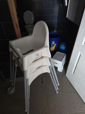 une chaise haute pour bébé dans une salle de bains, à côté des toilettes