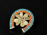 a close up of a brooch with a flower on it