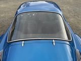 a close up of a blue car parked in a parking lot