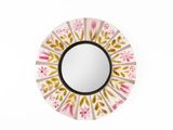 un miroir rond orné d'un motif rose et jaune