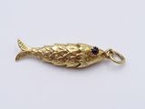 an image of a gold fish charm with garnets on it