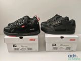 deux paires de baskets noires posées sur une boîte