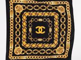 a black scarf with gold chains and a chanel logo
