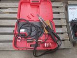 une caisse rouge contenant des outils, posée sur une palette