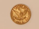 a close up of a gold coin on a white surface