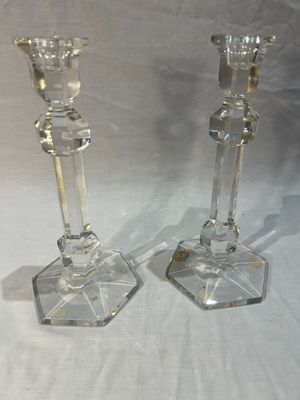 deux bougeoirs en verre transparent posés sur une table blanche