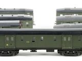 four green train cars sitting next to each other on a white surface