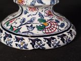 a white vase with a blue and red design on it