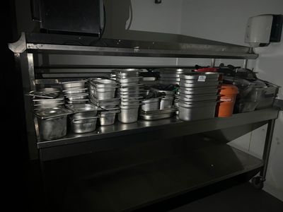 de nombreuses casseroles et poêles sur l'étagère de la cuisine