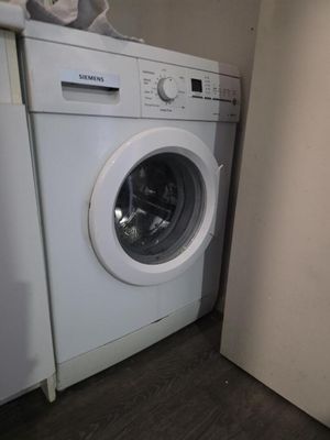 un lave-linge et un sèche-linge dans le coin d'une pièce