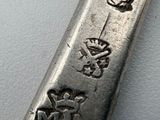 a silver spoon with a design on it on a white surface