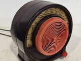 une radio noire et rouge posée sur une surface blanche