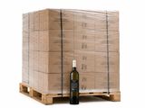 a bottle of wine sitting on a pallet next to a stack of boxes