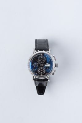 gros plan d'une montre sur une surface blanche avec un bracelet noir