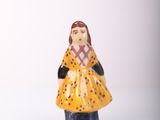 a small figurine of a woman in a yellow dress
