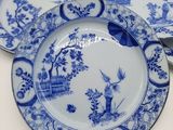 three blue and white plates with birds and flowers on them