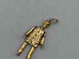 a close up of a gold charm on a white surface