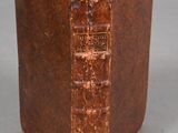 un vieux livre à la couverture brune posé sur une table