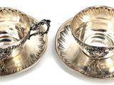 pair of silver plated tea cups and saucers with handles
