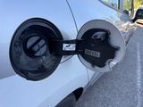 an electric car is plugged into a charging station in a parking lot