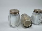 three salt and pepper shakers sitting next to each other on a white surface
