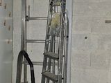 une photo d'une pièce avec une échelle et une machine à laver