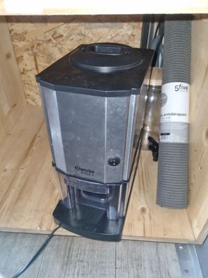 un mixeur noir et argent posé dans une boîte en bois