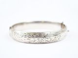 gros plan d'un bracelet en argent sur une surface blanche