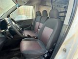 the interior of a white van with two black seats and a steering wheel
