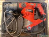 a red electric drill in a case on the floor