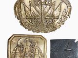 two gold and black metal belt buckles with a picture of a man and a woman