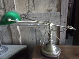 a green lamp that is on top of a wooden table