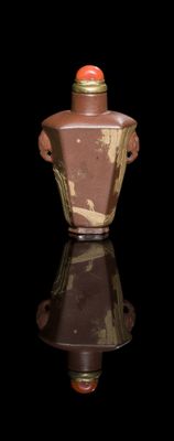 a brown vase with a red lid on a black surface