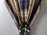 a close up of a shawl hanging on a hanger on a wall