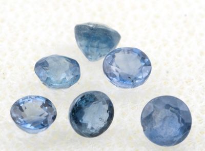 un groupe de cinq saphirs bleus posés sur une surface blanche