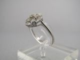 une photo d'une bague en diamant posée sur un socle transparent