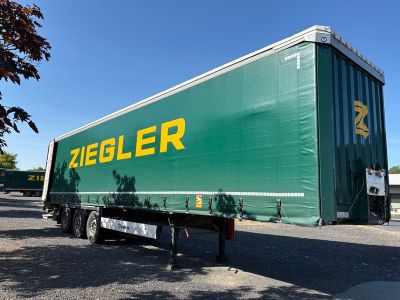 La remorque est verte et jaune, avec un logo Ziegler jaune sur le côté.