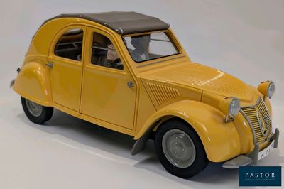 une petite voiture jaune posée sur une surface blanche